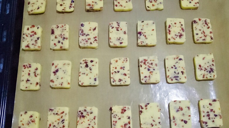 蔓越莓饼干,烤盘中铺上油纸，摆放在烤盘上，饼干之间留些空隙，以免烤的时候体积膨胀粘在一起
