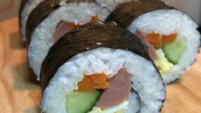 寿司卷,寿司刀每切一刀蘸一下凉开水，以防米粒粘连。