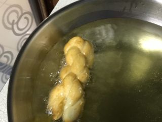 东北软炸麻花-妈妈的味道,锅热油，油温在170度左右（筷子插入有气泡）。下麻花前，两头拉住麻花两头，尽量拉长下油锅。