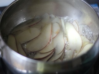 苹果玫瑰挞,锅中放入适量水，加入白糖，煮至白糖完全融化，放入切好的苹果片稍微煮一下，使苹果软化。