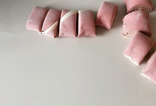 #最爱包子#粉红梦幻肉包,卷在一起，然后切成小段。