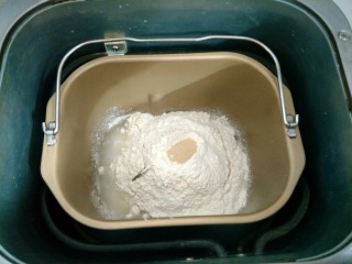豆沙面包圈,除黄油和红豆沙外，其余材料全部放进面包机，按先液体后面粉，面粉中间挖个洞埋上酵母，启动和面程序揉20分钟