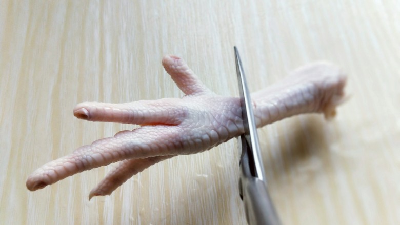 健康零食～香糟凤爪,把鸡爪剪开，首先将鸡爪的根部剪下来，如图。