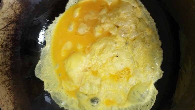 花菜青椒炒蛋,约15秒鸡蛋成行，用锅铲弄碎。