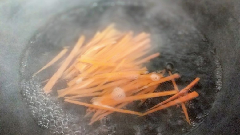 韩式石锅拌饭,再将切丝的胡萝卜焯水，锅中加入水，大火烧开，放入胡萝卜丝，1分钟捞出。