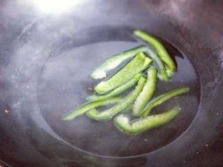 韩式石锅拌饭,将切好的青椒条焯水，锅中加入水，烧开后下入青椒条30秒捞出。