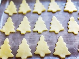 圣诞树饼干#预热圣诞节#,将面团依次做完，放有垫好油纸的烤盘中，并间隔一点距离。