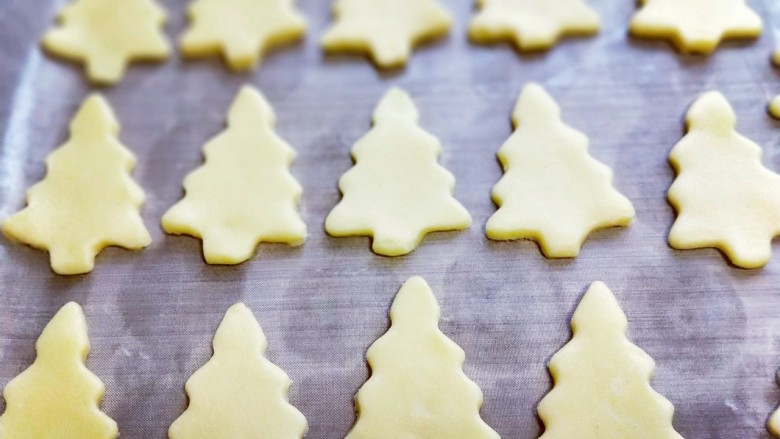 圣诞树饼干#预热圣诞节#,将面团依次做完，放有垫好油纸的烤盘中，并间隔一点距离。