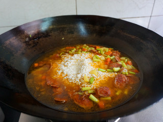 香肠土豆焖饭,再放入淘好的大米，小火慢煮片刻
