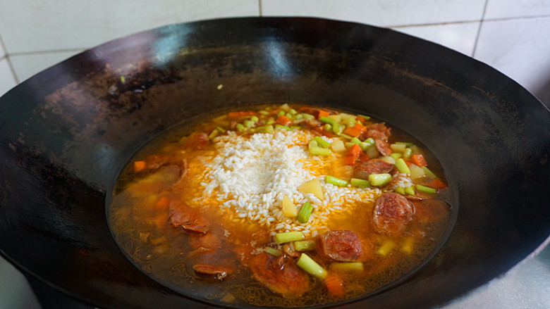 香肠土豆焖饭,再放入淘好的大米，小火慢煮片刻
