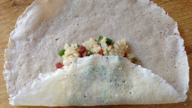 网红豇豆饼,把春卷皮的下端往上折，盖住米饭（如图）
