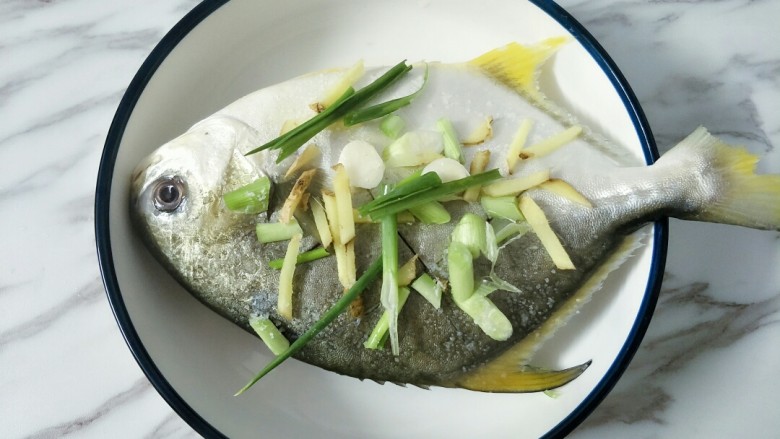 清蒸鲳鱼,金鲳鱼两面抹适量盐，放上葱段姜丝，鱼肚里也塞一点