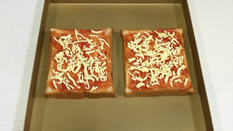 南极磷虾吐司披萨,撒上1/3的马苏里拉奶酪。