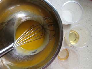 藜麦黑芝麻戚风,蛋黄打散，加入牛奶、油、朗姆酒，搅拌均匀
