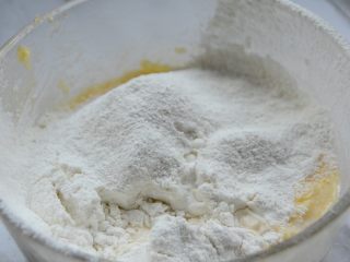 兔子纸杯蛋糕,倒入一般牛奶，过筛一半低筋粉，继续用打蛋器打匀