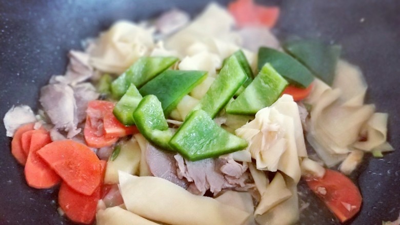彩蔬肉片炒干豆腐皮,加入切好的青椒。