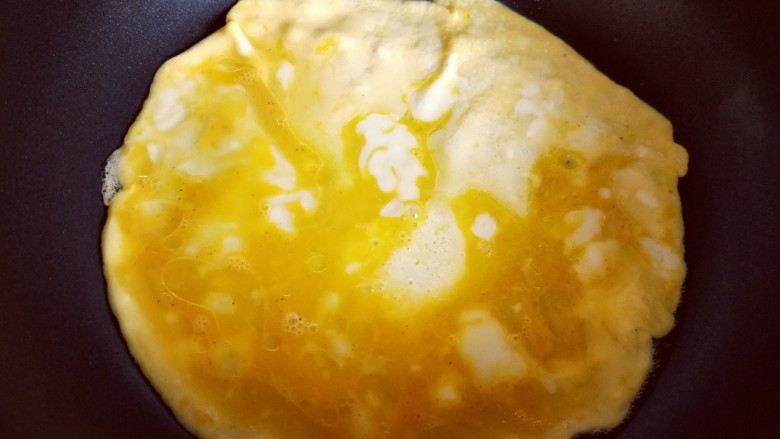 #适合冬天的菜#韭黄炒鸡蛋,起油锅，油温7成时倒入打散的蛋液，小火煎鸡蛋饼。
