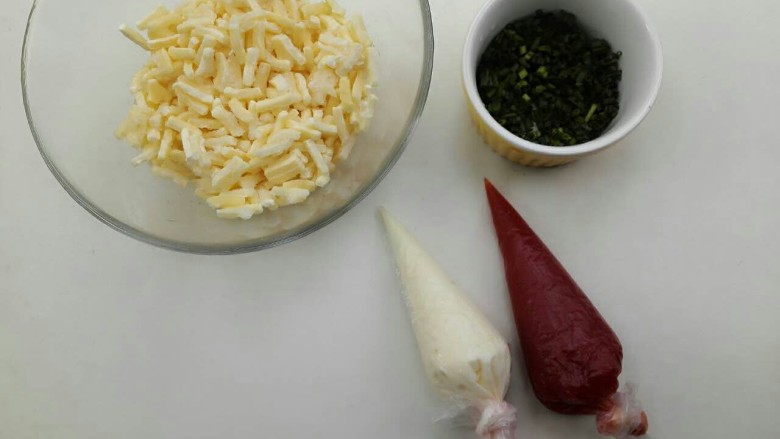芝士肉松面包,将番茄酱和沙拉酱装入裱花袋里，芝士从冰箱里拿出来解冻，香葱切碎。