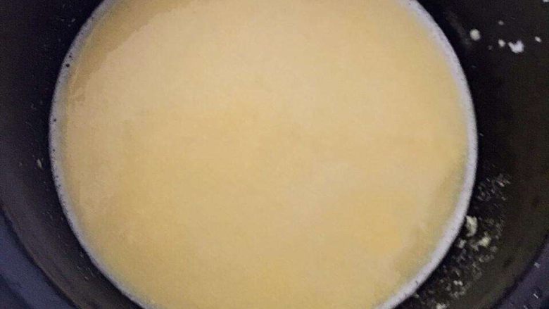宝宝辅食之奶香玉米饼,玉米糊分成两部分，一半做粥，一半等会儿做玉米饼。取一半的米糊放进锅里，然后加水小火慢慢熬煮