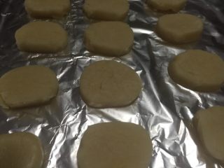 柠檬饼干（植物油版）,冻硬后取出，切成厚薄均匀的片，均匀摆放在烤盘上