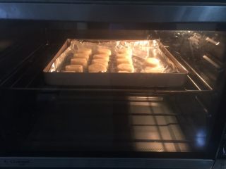 柠檬饼干（植物油版）,烤箱上下火150度预热好后放入烤盘，烤至表面微上色关火（我切得偏厚，约烤了13分钟表面便上色了），待余温烘至完全上色时取出，用烤网晾凉
