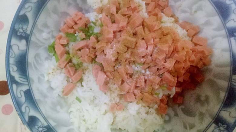 油炸米饭丸子#变废为宝#,切好的火腿肠 蒜苗 放到米饭碗里面，加适量盐  十三香