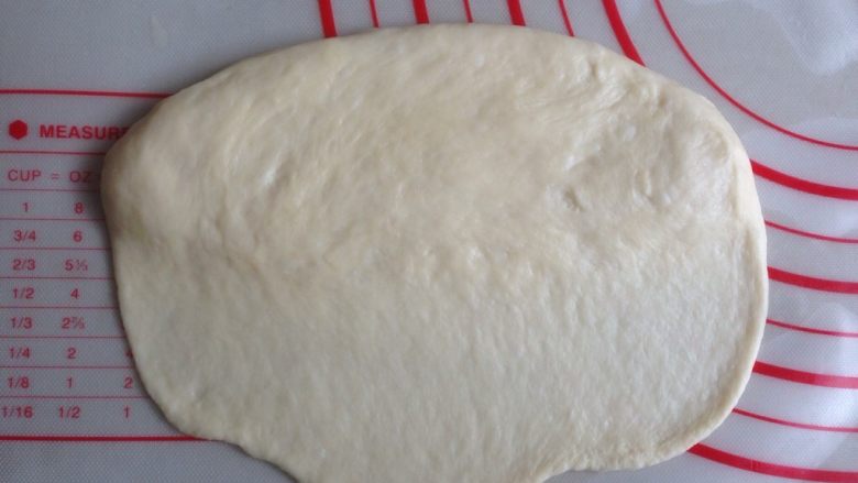 香肠面包,将松驰后的面团擀成15CM长的椭圆形，其中一条长边擀薄