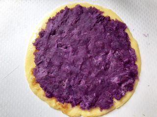 紫薯蛋卷,将备好紫薯泥用小勺在出锅的蛋饼上均匀摊开。