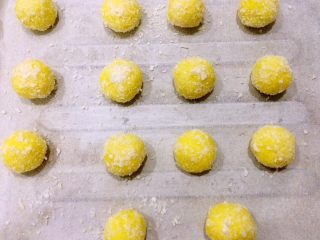 黄金椰丝球,圆球表面撒上材料外的椰蓉装饰。入烤箱中层180度15分钟