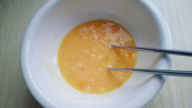 快手早餐～芝香馒头丁,用筷子将鸡蛋打散。