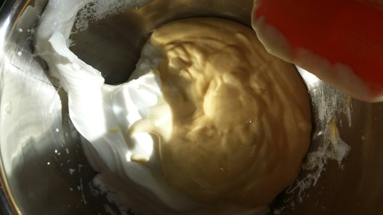 戚风杯子蛋糕,把拌匀的蛋黄糊倒入剩余的蛋白中，继续切拌的手法拌匀。