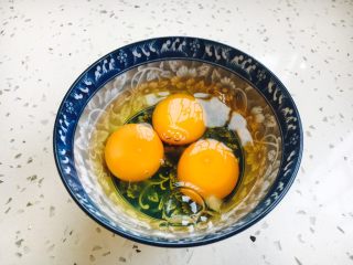 西红柿炒鸡蛋豌豆,把鸡蛋磕入碗中，搅打均匀。