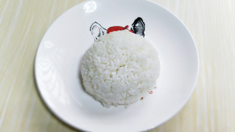 番茄炒蛋盖浇饭,将熟米饭装入碗中，用铲子压实，之后倒扣再盘子里，如图。