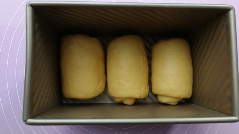 最爱面包+南瓜吐司,卷好的面团依次同方向摆入450g的吐司盒内