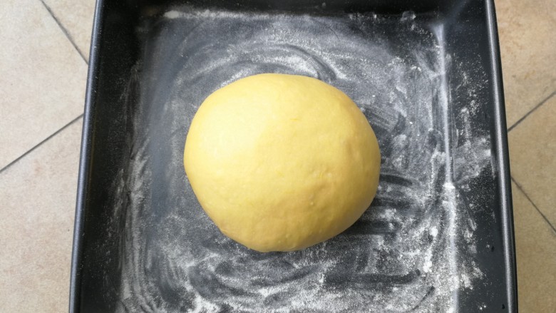 最爱面包+南瓜吐司,揉面完成后，将面团滚圆，放入撒了干粉防粘的烤盘里，加盖保鲜膜进行一发