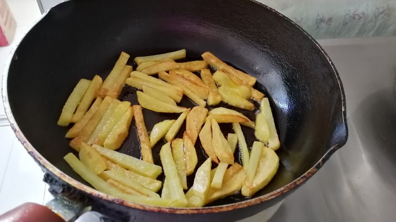 腊肠炒土豆条蒜苔,土豆 条煎至金黄色，煎熟了。