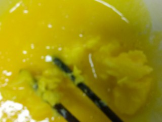 自制芝麻蛋糕,蛋黄用筷子搅散，加入黄油。