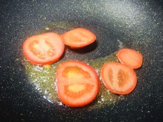 #一碗面条#茄汁双色太阳面,锅里面放一点油，把番茄片放进去翻炒