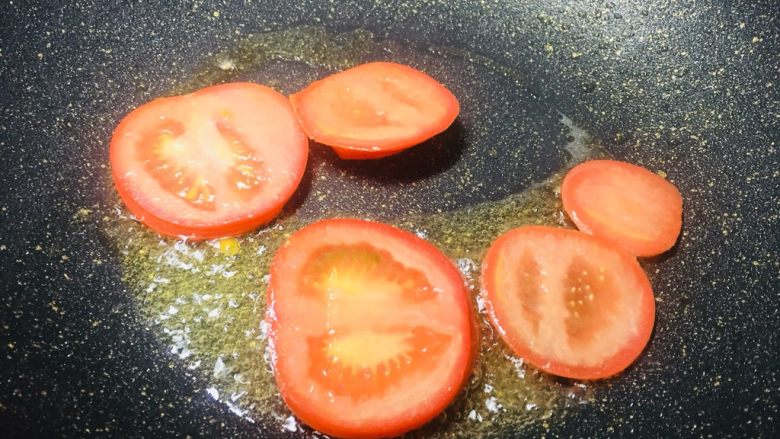 #一碗面条#茄汁双色太阳面,锅里面放一点油，把番茄片放进去翻炒