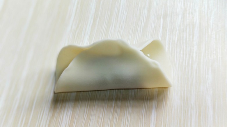 芹菜猪肉水饺,将饺子皮对折，如图。