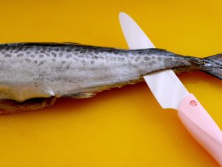 最爱包子+烟台大馅鲅鱼包子,把鱼放到菜板上、用刀从鱼的尾部开始片