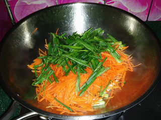 青蒜炒胡萝卜,再倒入胡萝卜丝和蒜叶、滴少许清水