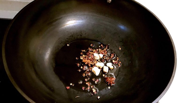 红烧猪尾,锅内加入大豆色拉油烧热后加入花椒粒，山奈和大料，煸炒出香味