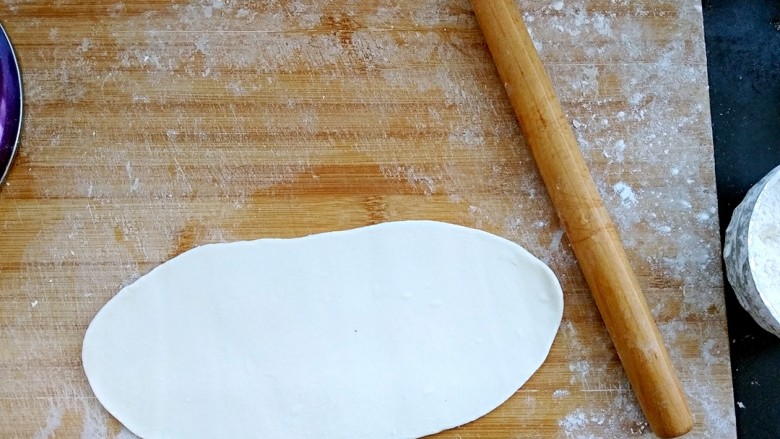 烫面鸡蛋饼,把面团分成均匀的几个小面团后，拿一个出来擀成牛舌状大约15-20厘米长。