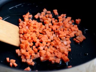 杂蔬丸子饭团,锅内倒入少许色拉油，加热至8分热，加入胡萝卜翻炒；