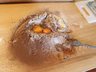 自制巧克力意大利面,将杜兰小麦粉、面粉、可可粉、少许盐过筛置于处理台上，推成小山，挖出一个深井，将蛋打入中间的井洞。
