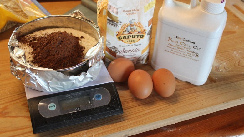 自制巧克力意大利面,制作手工意大利面，粉类和蛋的比率大约是1杯250CC面粉（约125g）用一个大蛋。这次因为是中型蛋，又多加了可可粉，所以用了4颗蛋。