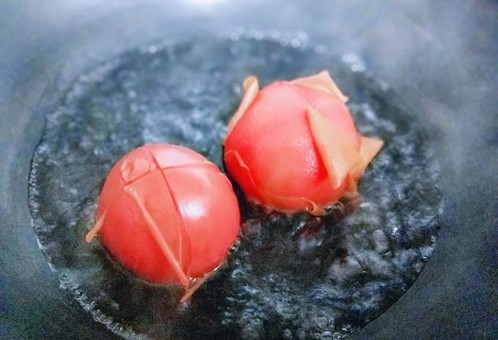 一碗面条＋番茄鸡蛋打卤面,锅中加入清水，大火烧开后，加入划好十字刀的番茄，煮至皮裂开，捞出即可。