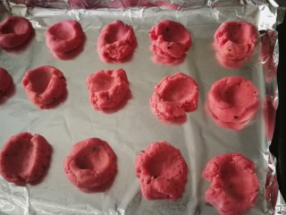 红粉手印饼干,取出面团 做成小剂子 在烤盘上码好 用拇指在每个剂子中间按一下