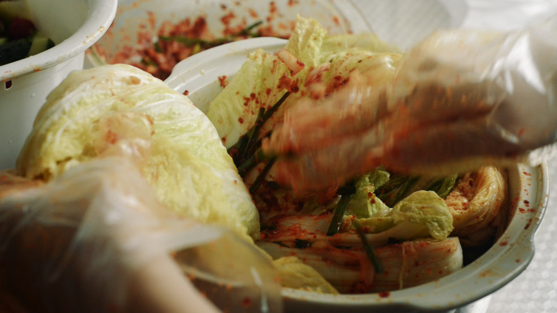 制作自家口味的韩式泡菜,把辣椒糊涂抹在每片叶片中间。